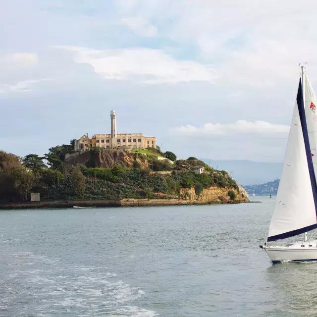 A sailboat passes in front of 阿尔卡特拉斯岛 Island in 贝博体彩app.